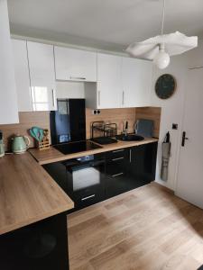 a kitchen with white cabinets and a black counter top at Le domaine de Bachmay in Laval