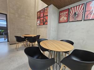 um restaurante com duas mesas e cadeiras e cartazes na parede em Pamplona Studios by Housi em São Paulo