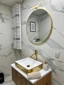 a bathroom with a gold sink and a mirror at SKY TOWER APARTMENTS in Warsaw