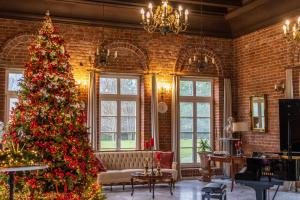 a christmas tree in a room with a brick wall at Dworek Atrium in Tomaszów Lubelski