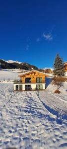 a house in the middle of a snow covered yard at Schneiderhof, Urlaub auf dem Bauernhof in Ridanna