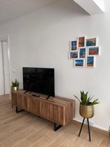 uma sala de estar com uma televisão de ecrã plano numa mesa de madeira em Bungalow Ara em Puerto del Carmen