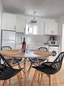 a kitchen with a table with chairs and a bottle of wine at Bungalow Ara in Puerto del Carmen