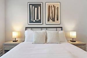 1 dormitorio con 1 cama blanca y 2 lámparas en 1BR Lively and Fully Furnished Apartment - Kenwood 5408, en Chicago