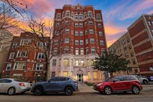 two cars parked in front of a large building at Lively & Fully Furnished 1BR Apartment - Kenwood 408 in Chicago