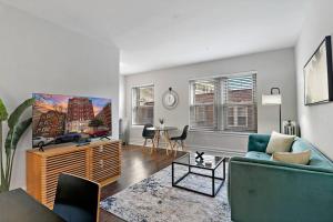 a living room with a couch and a tv at Lively & Fully Furnished 1BR Apartment - Kenwood 408 in Chicago