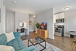 a living room with a blue couch and a kitchen at Lively & Fully Furnished 1BR Apartment - Kenwood 408 in Chicago