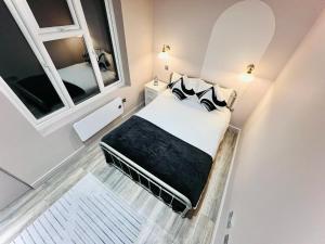 a small bedroom with a bed and two windows at Central studios: Exceptional standard for a memorable stay in London
