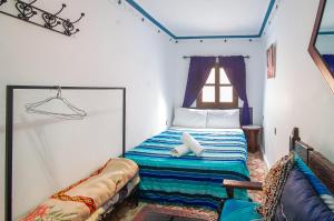 a small bedroom with a bed with a window at Dar Chourafa Riad in Chefchaouen