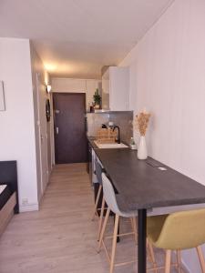 cocina con mesa y sillas en una habitación en Studio à 100m de la plage, en Bénodet
