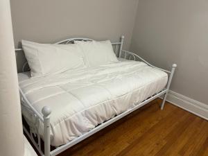 Cama blanca con sábanas y almohadas blancas en Cozy Home Away From Home 3 bedrooms 5 beds 1 bath en Rochester