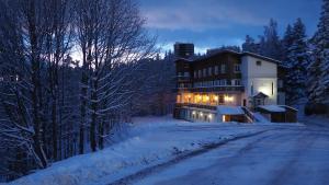 a house on a snowy road in the snow at Auberge de Jeunesse HI Chamrousse in Chamrousse