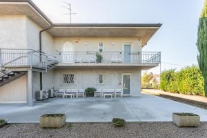 een huis met een balkon en stoelen op de patio bij Bed gold in Castelnuovo del Garda