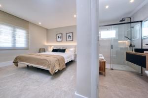 a bedroom with a bed and a walk in shower at la Joya Suites- near the beach in Puerto del Carmen