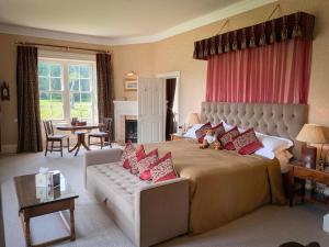 a large bedroom with a large bed and a couch at Swinton Park in Masham