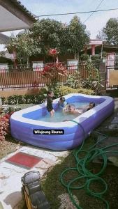 un grupo de personas en una balsa azul en una piscina en Berkah Huni , CIATER, en Sarireja