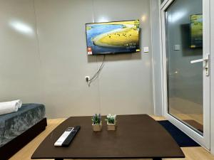 a living room with a coffee table and a tv at H&T PJ Gasing - Cabin Studio - Netflix & Free Parking in Petaling Jaya