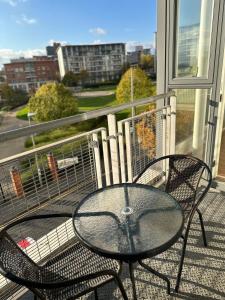 d'une table en verre et de deux chaises sur un balcon. dans l'établissement Luxury 1 Bedroom Apartment - City Centre - Balcony - Near O2 Academy, à Birmingham
