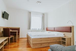 1 dormitorio con 1 cama grande y escritorio en Gasthaus zur Waldschenke en Zeltweg