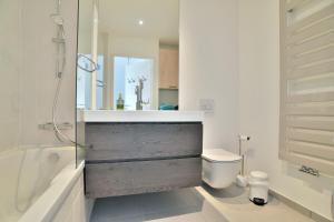 ein Bad mit einer Badewanne, einem WC und einer Dusche in der Unterkunft Les Flots de PortMer in Cancale