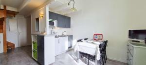 a small kitchen with a table and a kitchen with a sink at Appartement dans résidence avec piscine in La Couarde-sur-Mer