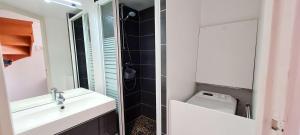a bathroom with a sink and a toilet and a mirror at Appartement dans résidence avec piscine in La Couarde-sur-Mer