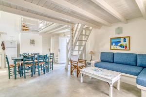 a living room with a blue couch and a table at Great house w/ BBQ in Paros in Santa Maria