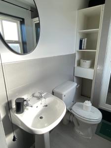 a bathroom with a sink and a mirror and a toilet at Stylish Darlington Townhouse Near A1 A66 & A19 Breakfast in Darlington