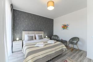 a bedroom with a large bed and a wall at MaBu Apartment -2 camere spatios cu parcare subterana, Tractorul Brasov in Braşov