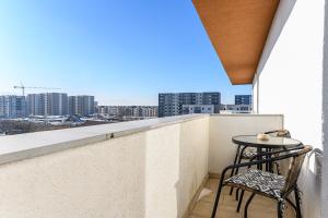 a balcony with a table and chairs and a view of the city at MaBu Apartment -2 camere spatios cu parcare subterana, Tractorul Brasov in Braşov