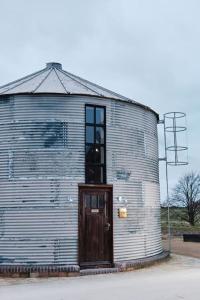 um grande edifício de metal com uma porta lateral em The Grain Store em Sutton Bonington