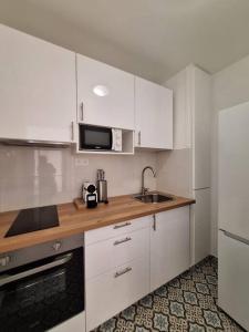 uma cozinha com armários brancos, um lavatório e um micro-ondas em Charmant T2 rénové et lumineux - SUR3 em Suresnes
