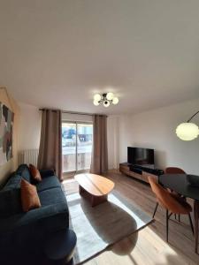 uma sala de estar com um sofá azul e uma mesa em Charmant T2 rénové et lumineux - SUR3 em Suresnes