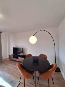 uma sala de jantar com uma mesa preta e cadeiras em Charmant T2 rénové et lumineux - SUR3 em Suresnes