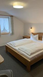 ein Schlafzimmer mit einem großen Bett in einem Zimmer in der Unterkunft Pension Gregory in Schönau am Königssee
