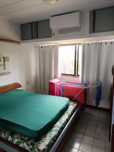 een kleine kamer met een bed en een raam bij Guarajuba Summer Flat in Guarajuba +124 foto's