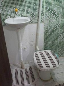 a bathroom with a toilet and a sink at Camburi Casa Shamballa in São Sebastião