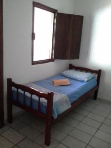 a small bed in a room with a window at Camburi Casa Shamballa in São Sebastião