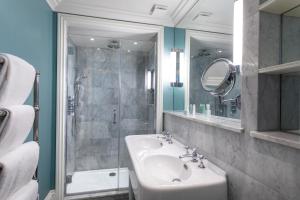 a bathroom with a sink and a glass shower at Roslin Beach Hotel in Southend-on-Sea