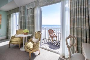a room with a balcony with a table and chairs at Roslin Beach Hotel in Southend-on-Sea