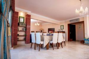 アガディールにあるSpacious BeachView Condo Marina - Families Onlyのダイニングルーム(テーブル、白い椅子付)