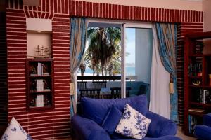 - un salon avec un canapé bleu et une fenêtre dans l'établissement Spacious BeachView Condo Marina - Families Only, à Agadir