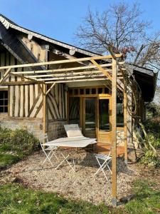 una sedia e un tavolo di fronte a una casa di Cottages Normands (deux maisons) a Houlgate