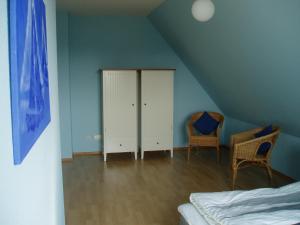 a attic room with a bed and two chairs at Ferien unterm Reet in Prerow