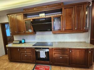 a kitchen with wooden cabinets and a stove top oven at Пуща Водиця in Vyshhorod
