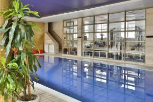 a large swimming pool in a building with a building at Adina Apartment Hotel Budapest in Budapest
