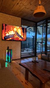 a living room with a fireplace and a table at Pirates Nest Cottages in Ulcinj