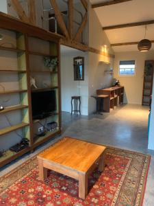 een woonkamer met een salontafel en een keuken bij B&B de Brem in Berkel-Enschot