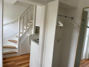 escalera blanca en una habitación con paredes blancas en Haus-Amici, en Tinnum