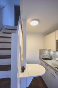 una cocina con una mesa blanca y una escalera en Haus-Amici, en Tinnum